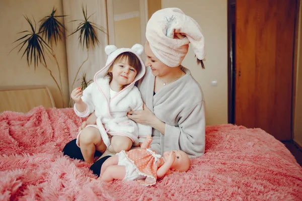 Mãe com filha sentada em uma cama — Fotografia de Stock