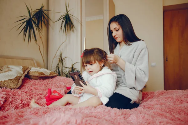 Anne ile kızı yatağa oturmuş