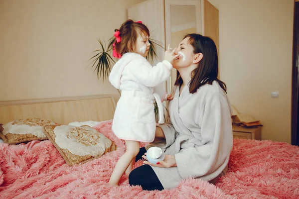 Mãe com filha sentada em uma cama — Fotografia de Stock