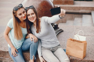 Bir şehirde alışveriş çantası ile sevimli kızlar