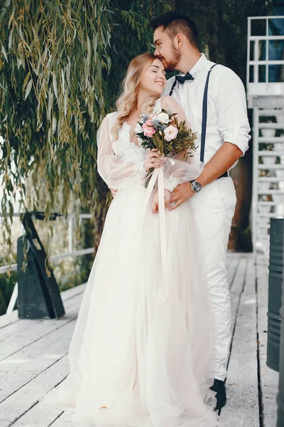Schöne Braut mit ihrem Mann in einem Park — Stockfoto