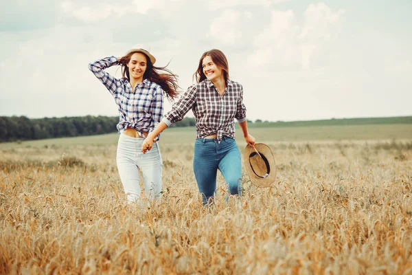 Belle ragazze hanno un riposo in un campo — Foto Stock