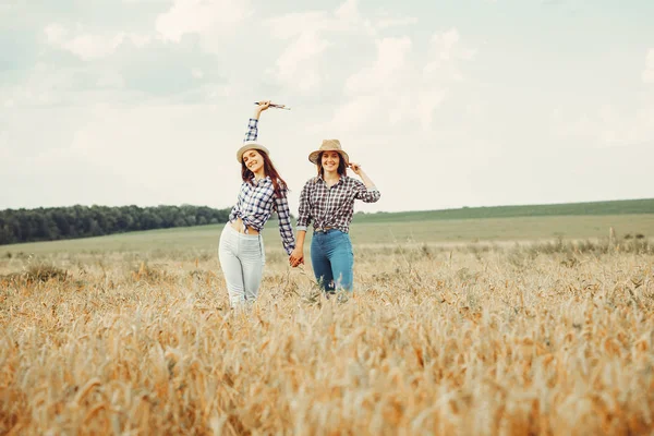 As meninas bonitas têm um resto em um campo — Fotografia de Stock