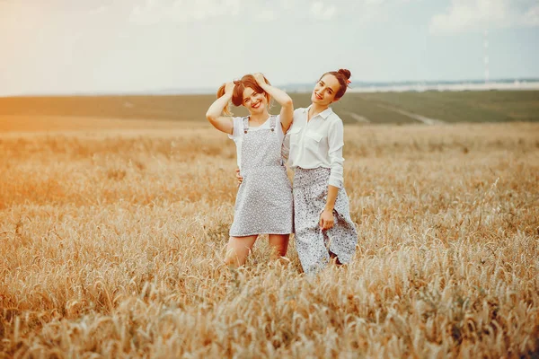 As meninas bonitas têm um resto em um campo — Fotografia de Stock