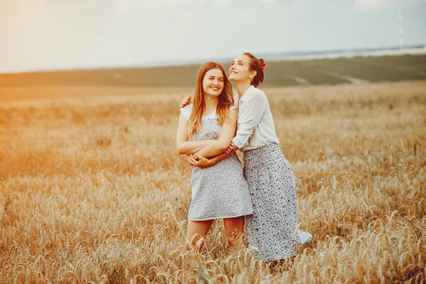 Belle ragazze hanno un riposo in un campo — Foto Stock