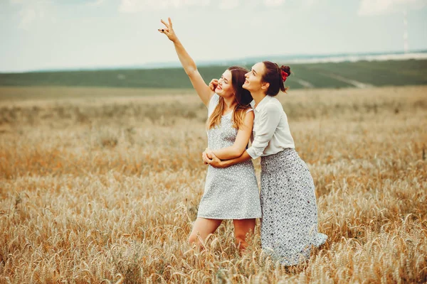 As meninas bonitas têm um resto em um campo — Fotografia de Stock