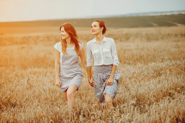Beautiful girls have a rest in a field — Stock Photo, Image