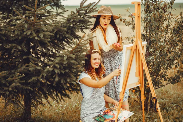Dwie piękne dziewczyny rysując w polu — Zdjęcie stockowe