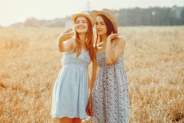 As meninas bonitas têm um resto em um campo — Fotografia de Stock