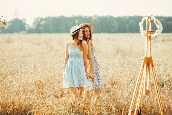 As meninas bonitas têm um resto em um campo — Fotografia de Stock