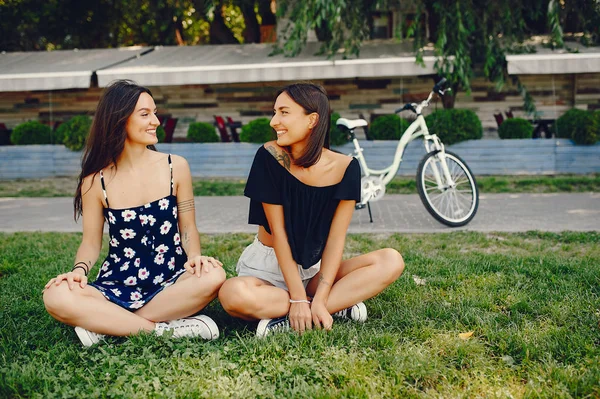 Ragazze alla moda a piedi in un parco estivo — Foto Stock