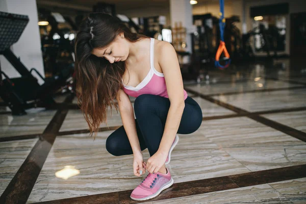 Een mooi meisje is bezig in een sportschool — Stockfoto