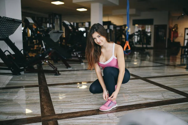 Een mooi meisje is bezig in een sportschool — Stockfoto