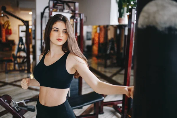 Una hermosa chica se dedica a un gimnasio —  Fotos de Stock