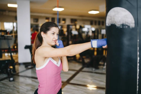 En vacker flicka är engagerad i ett gym — Stockfoto