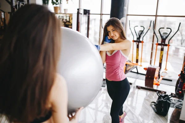 Twee mooie atletische meisjes zijn bezig met de sportschool — Stockfoto