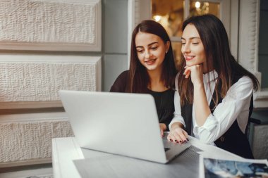 İki kız bilgisayarda çalışıyor.