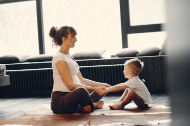 Küçük oğlu olan anne evde yoga yapıyor