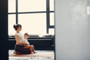 Küçük oğlu olan anne evde yoga yapıyor