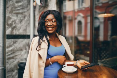 Siyah kadın bir kafede kahve içiyor
