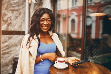 Siyah kadın bir kafede kahve içiyor