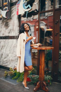 Siyah kadın bir kafede kahve içiyor