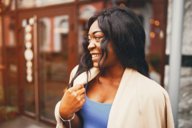 Bir sonbahar şehrinde duran siyah kadın