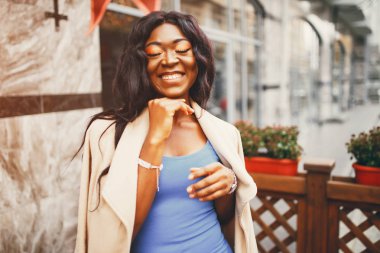 Bir sonbahar şehrinde duran siyah kadın