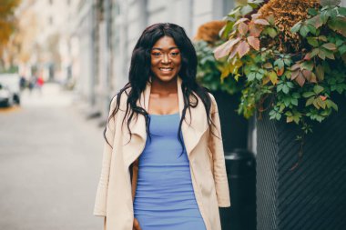 Bir sonbahar şehrinde duran siyah kadın