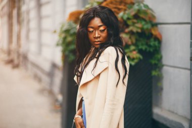 Bir sonbahar şehrinde duran siyah kadın