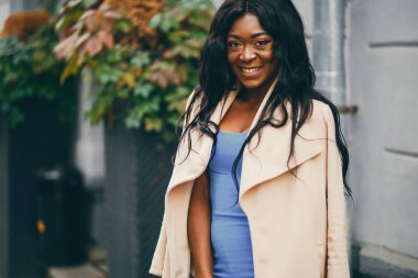 Bir sonbahar şehrinde duran siyah kadın