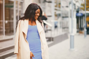 Bir sonbahar şehrinde duran siyah kadın