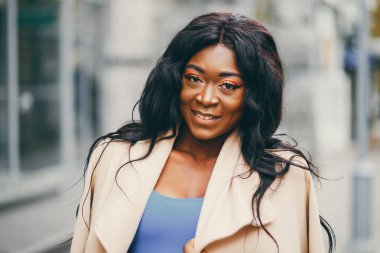 Bir sonbahar şehrinde duran siyah kadın