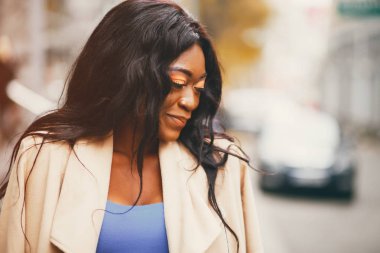 Bir sonbahar şehrinde duran siyah kadın