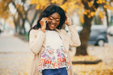 Bir sonbahar şehrinde duran siyah kadın