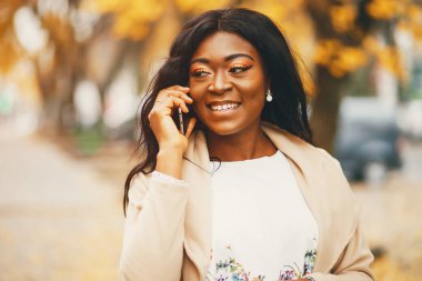 Bir sonbahar şehrinde duran siyah kadın