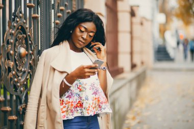 Bir sonbahar şehrinde duran siyah kadın