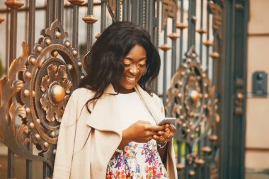 Bir sonbahar şehrinde duran siyah kadın