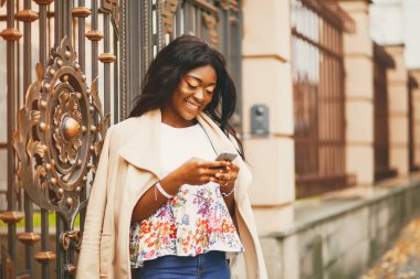 Bir sonbahar şehrinde duran siyah kadın