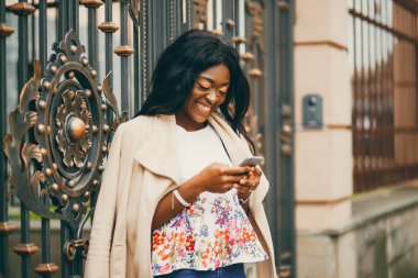 Bir sonbahar şehrinde duran siyah kadın