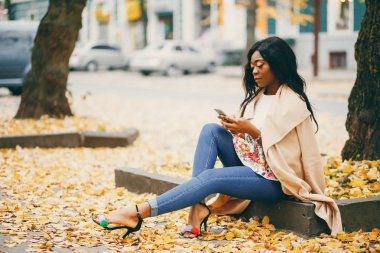 Bir sonbahar şehrinde oturan siyah kadın