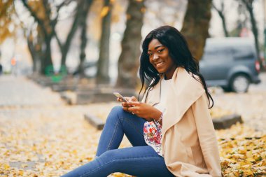 Bir sonbahar şehrinde oturan siyah kadın