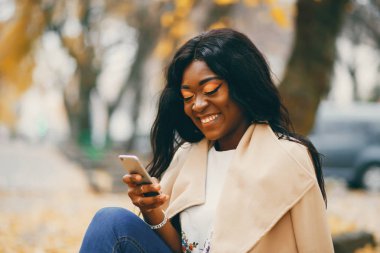 Bir sonbahar şehrinde oturan siyah kadın