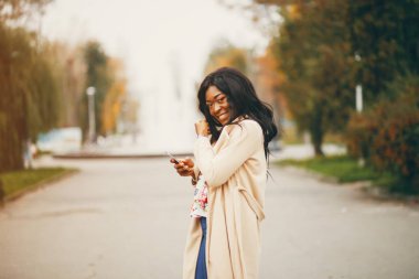 Bir sonbahar şehrinde duran siyah kadın
