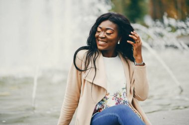 Bir sonbahar şehrinde oturan siyah kadın