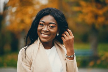 Bir sonbahar şehrinde oturan siyah kadın