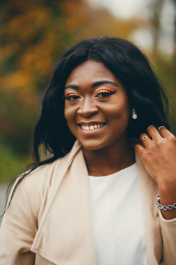 Bir sonbahar şehrinde oturan siyah kadın