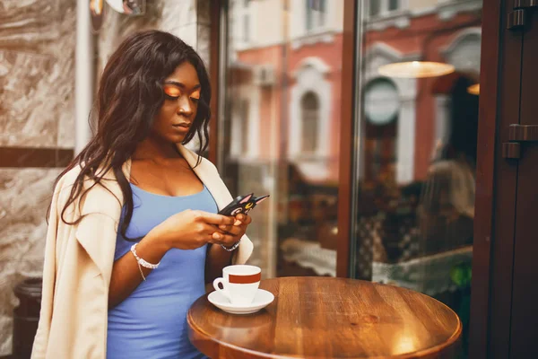 Black woman drinking a coffee in a cafe