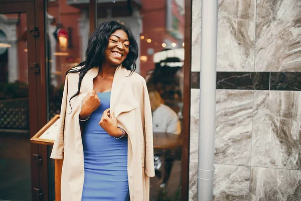 Bir sonbahar şehrinde duran siyah kadın