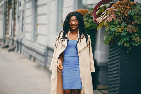 Mulher negra em pé em uma cidade de outono — Fotografia de Stock